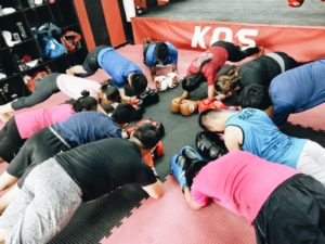 KOS Gym Members Engaging in Group Plank Exercise