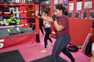 Female students showcasing their shadow boxing prowess with focus.
