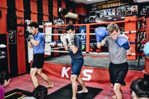 Diverse group of students passionately engaged in shadow boxing during training.