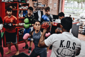 Female Boxer Perfecting Punch Technique with Instructor